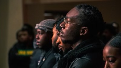 Morehouse students stand side to side in black clothing, protesting plans for a new Atlanta police training center.